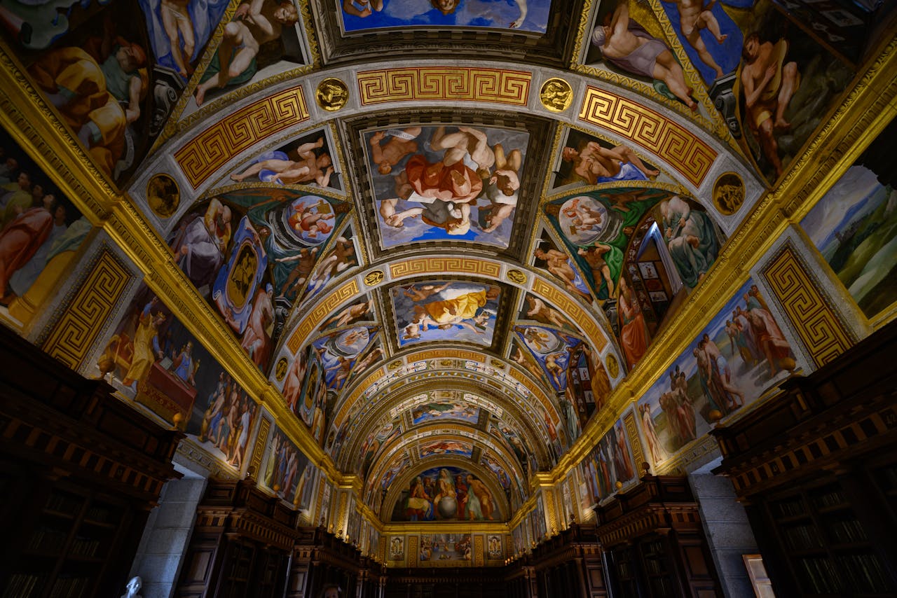 Ornate ceiling paintings in a historic library in Madrid, showcasing Renaissance art.